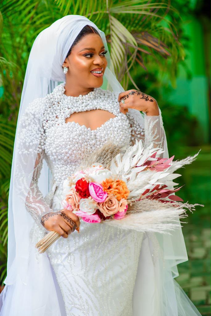 Bride holding a soft white bouquet with blush florals