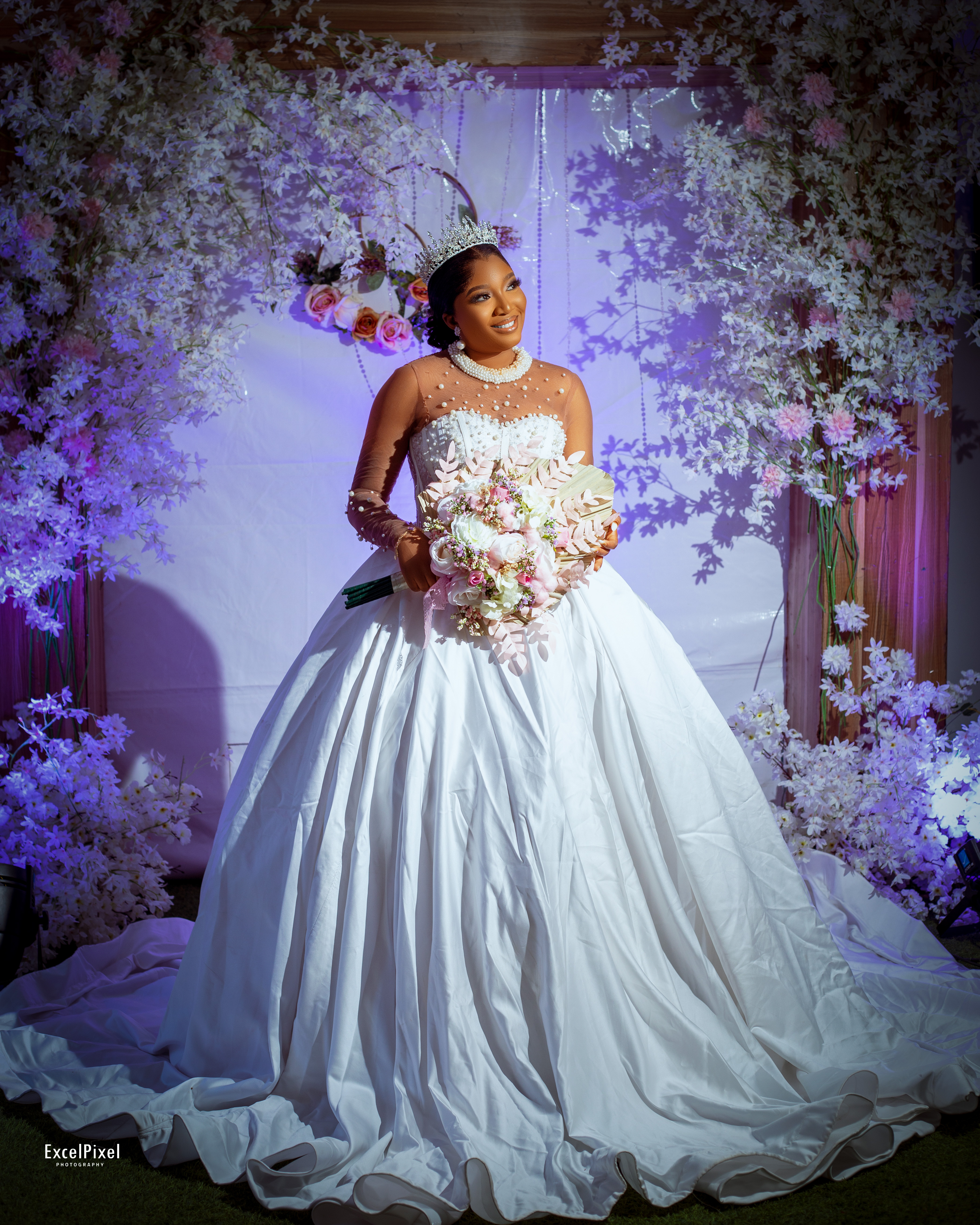 Close-up of a bridal veil flowing beside a white gown